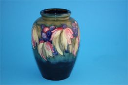 A Moorcroft ovoid shape vase "leaf and berry" pattern in a graduated green and blue ground.