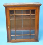 An Edwardian mahogany wall cabinet with single glazed door. 82 cm wide