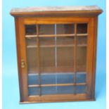 An Edwardian mahogany wall cabinet with single glazed door. 82 cm wide