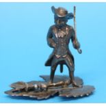 A white metal Middletown Plate Company, USA monkey, standing on a leaf dressed in a tricorn hat