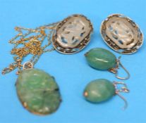 A pair of white metal white carved jade clip on earrings, a carved jade pendant and a pair of jade