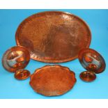 Two copper Arts & Crafts style trays and a pair of circular wall sconces all engraved by H Barnes,