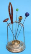 A silver hat pin stand, Chester 1914 and five decorative hat pins.