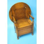 A small oak monk's bench with circular table top and rising seat.  75 cm diameter