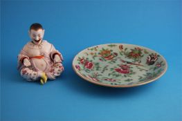 A Chinese Canton enamel circular plate and a porcelain seated Chinese nodding figure.  25 cm