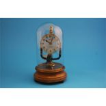 A Pinchin Johnson 800 day electric clock under a glass dome and supported on a wooden plinth.  28 cm