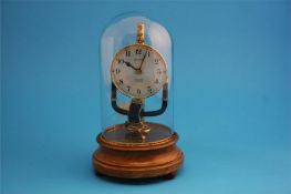 A Pinchin Johnson 800 day electric clock under a glass dome and supported on a wooden plinth.  28 cm