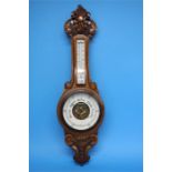 A carved oak 2 glass barometer.  89 cm long.