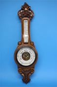 A carved oak 2 glass barometer.  89 cm long.