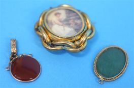 A Victorian circular cameo pendant; a Pinchbeck swivel brooch and a jade oval pendant. (3)