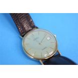 A Gentleman's 9ct gold Roamer wrist watch, champagne dial with batons, date aperture, on brown