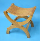 A Robert "Mouseman" Thompson oak X frame stool with slung leather seat, carved mouse to the side.