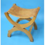 A Robert "Mouseman" Thompson oak X frame stool with slung leather seat, carved mouse to the side.