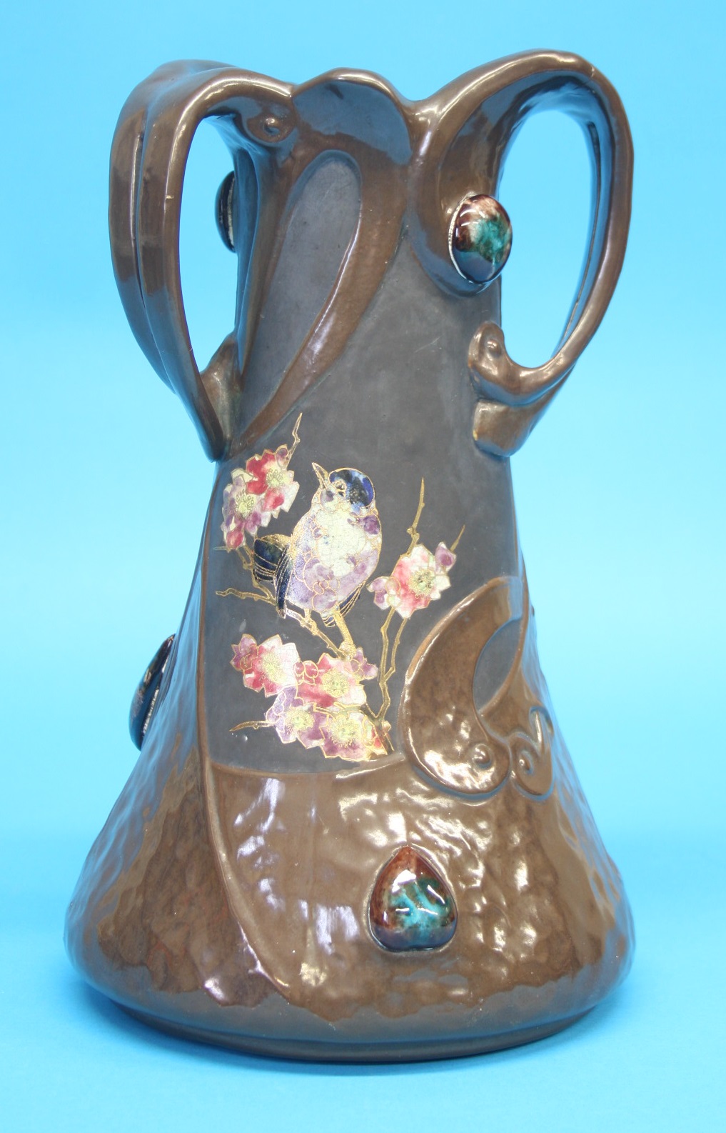 A Bretby Art Nouveau vase with moulded strapwork decoration in faux copper and cabachon style