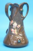 A Bretby Art Nouveau vase with moulded strapwork decoration in faux copper and cabachon style