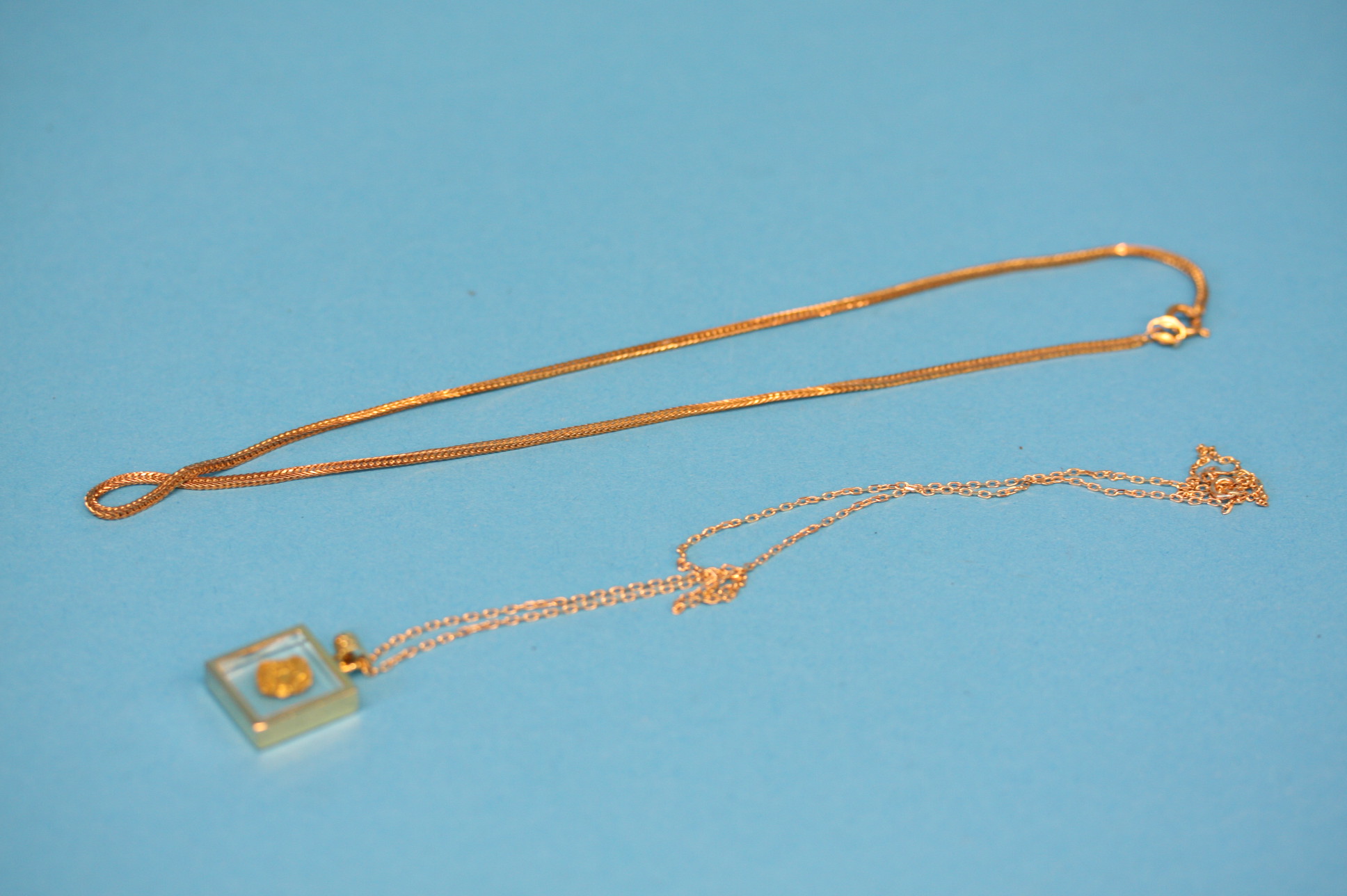 A 9ct gold chain.  Weight 3.9 grams and another 9ct gold chain with a small nugget of gold.