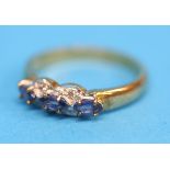 A 9ct gold ring set with three blue sapphires and four diamonds.  Ring size N.