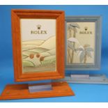 Two Rolex advertising stands and a Rolex ink blotter.