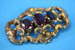 A Victorian gold pierced brooch set with three garnets.  Total weight 7.6 grams