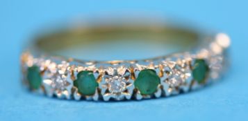 A 9ct gold half hoop eternity ring set with four emeralds and five diamonds.  Ring size N.