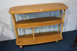 An Ercol Golden Dawn oblong three tier trolley with turned supports.