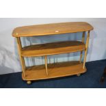 An Ercol Golden Dawn oblong three tier trolley with turned supports.