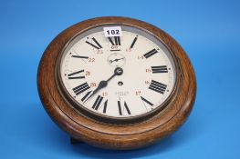 A Smiths Empire oak cased circular wall clock with painted dial.  28 cm diameter.