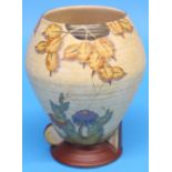 A Crown Devon Fielding vase decorated with a spider's web and colourful flowers on a beige ground,