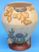 A Crown Devon Fielding vase decorated with a spider's web and colourful flowers on a beige ground,