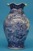 A Chinese blue and white vase with crimped rim, decorated with birds in a landscape.  37 cm high.