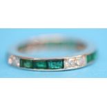 A platinum emerald and diamond eternity ring.