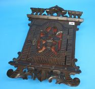 A small walnut wall mounted cabinet with pierced fretwork domed door and scrolling decoration.  51