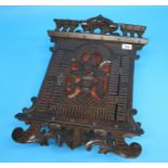 A small walnut wall mounted cabinet with pierced fretwork domed door and scrolling decoration.  51