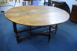 A large oak gateleg dining table with turned legs and plain uniting stretcher.  153 cm long