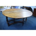 A large oak gateleg dining table with turned legs and plain uniting stretcher.  153 cm long