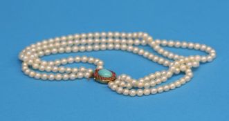 A three row pearl necklace with a 14ct gold catch.