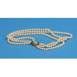 A three row pearl necklace with a 14ct gold catch.