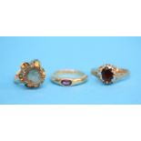 Three 9ct gold rings, one set with a garnet the other with a large citrine and a purple stone set