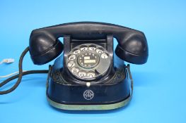 A traditional Bell telephone with bakelite receiver and metal decorated body with circular dial
