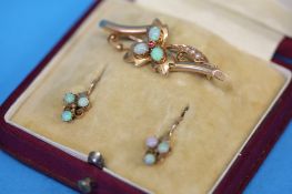 A gold pierced bar brooch set with three small opals, a pair of gold and opal earrings and a