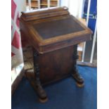 A Victorian walnut Davenport with domed and rising top, four frieze drawers and platform base with