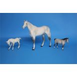 A large Beswick grey horse and two grey foals.