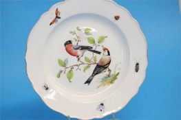 A Meissen plate, the centre decorated with birds, the border with butterflies and insects, cross
