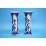 A pair of Chinese blue and white spill vases with flared rims, cylindrical bodies decorated with