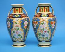 A pair of Noritake vases with gilt looped handles decorated with colourful flowers on a yellow and