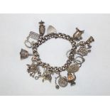 A silver charm bracelet with 12 charms, approx 86 grams