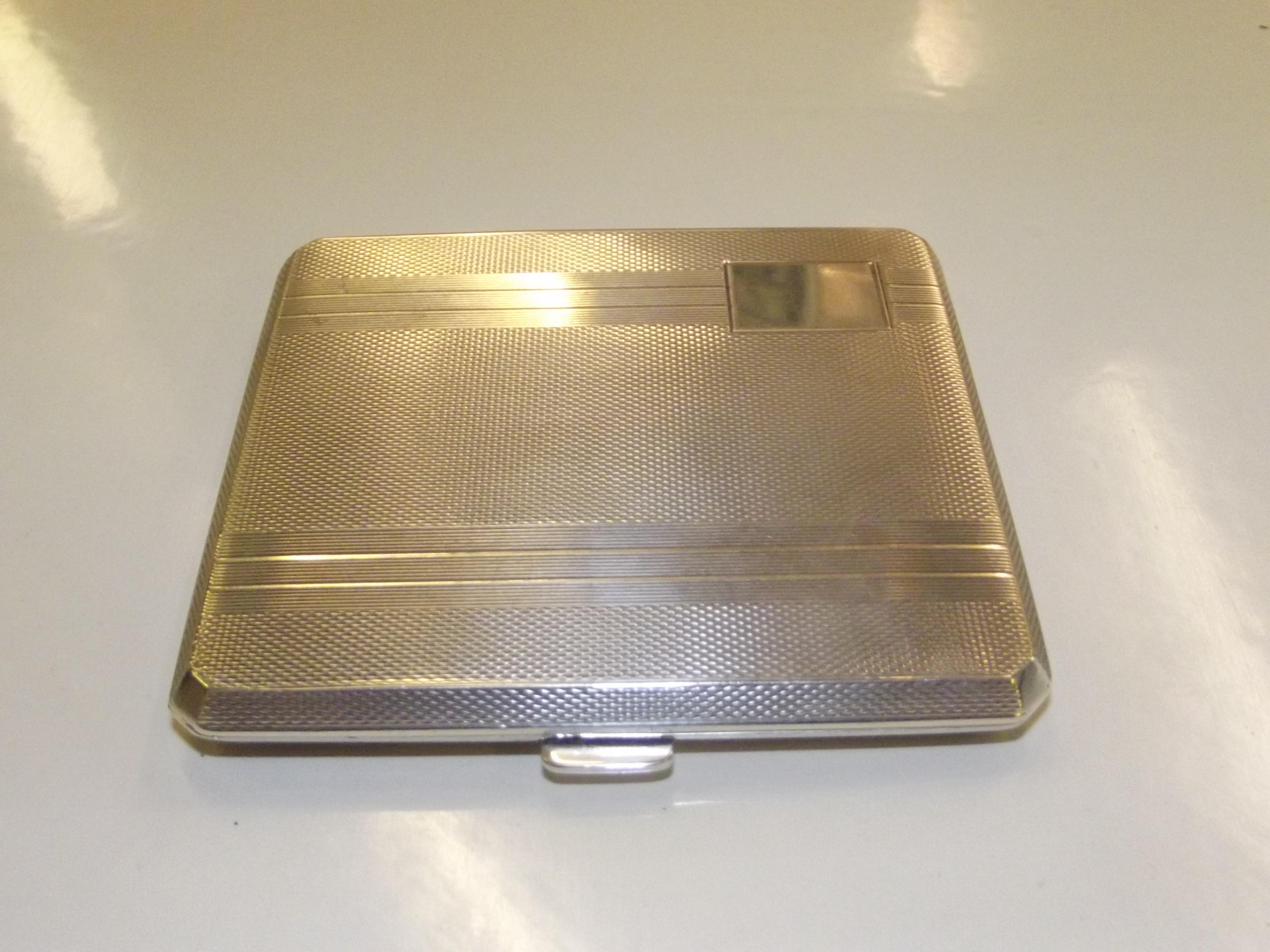 A vintage silver cigarette case in the art deco style, engine turned decoration, vacant