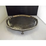 A Large Silver Salver Shaped edge on four ball and claw feet, London 1932, Diameter 37cm, 1.253kg