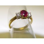 18 carat gold ring set with a central ruby flanked by two diamonds, size M 1/2