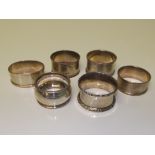 Six assorted silver napkin rings, two engine turned, two of plain form, one with engraved decoration